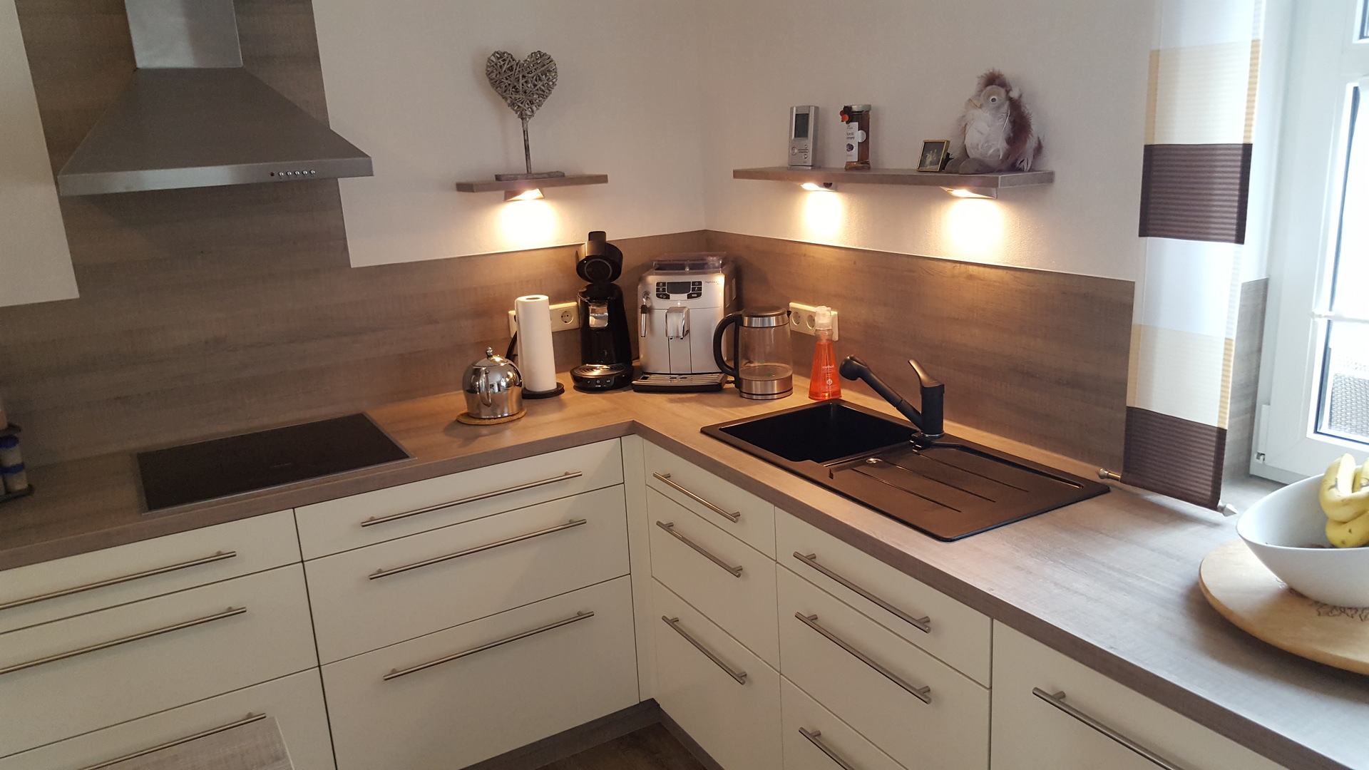 Küche in L-Form mit Spüle und Kochfeld. 