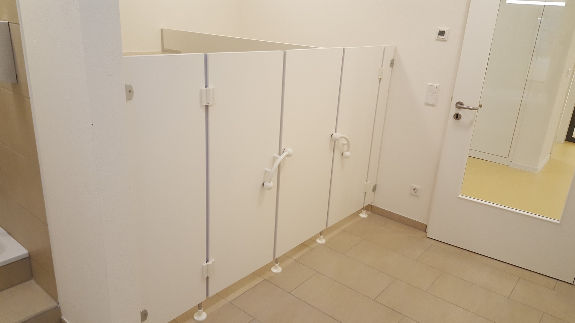 Weiße Toilette, mit kleinen Türen für Kinder