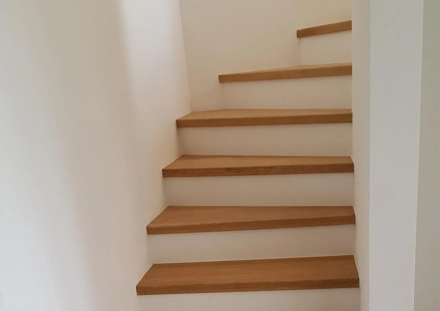 Treppe in hellem Holz mit weiß. 